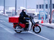 雪のなかを走る郵政バイク（宮城県南三陸町）